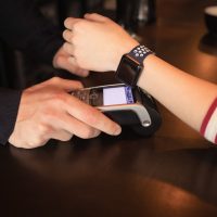woman-paying-through-smartwatch-using-nfc-technology_107420-96177